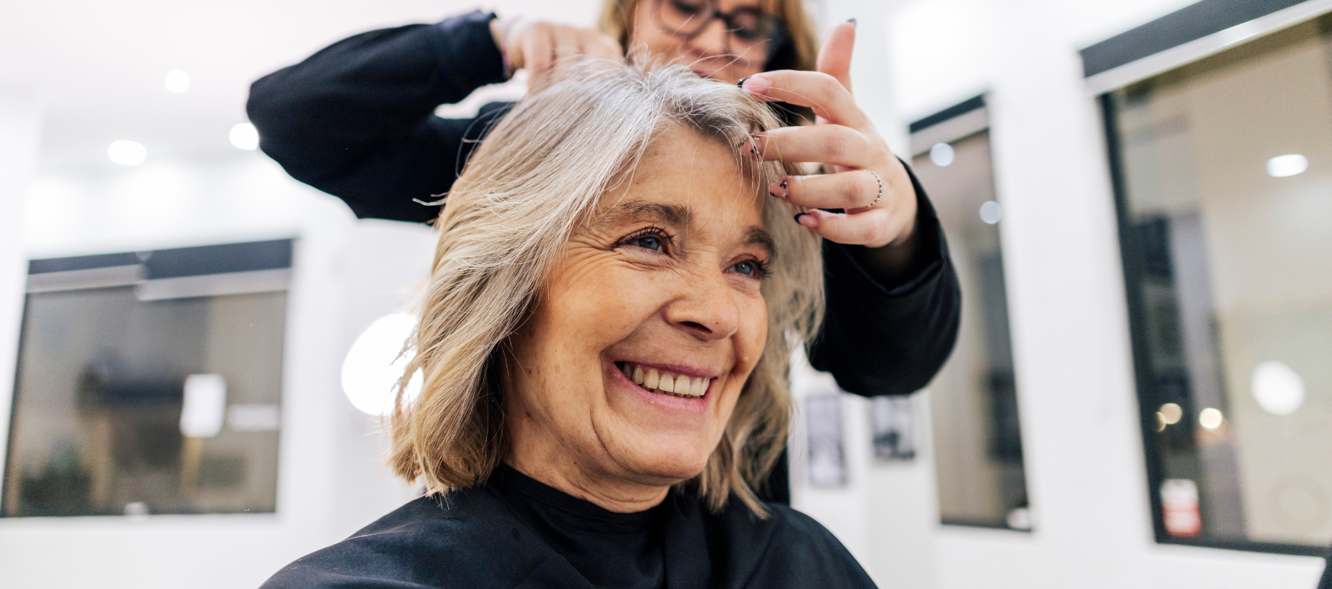 Vrouw met natuurlijk grijs haar in de salon